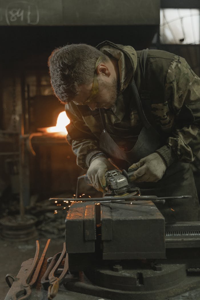 Mastering the First Impression: Your intriguing post title goes here A skilled blacksmith engaged in metal crafting and shaping inside a forge, showcasing sparks and precision.